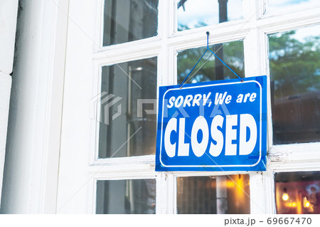 A Sign board of sorry we are closed hang on door of business. A Sign board of sorry we are closed hang on door of business. 69667470