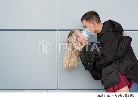 Young, happy, loving couple wearing masks and kissing 69668299