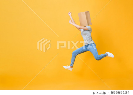 Anonymous woman with head covered with paper bag jumping Anonymous woman with head covered with paper bag jumping 69669184