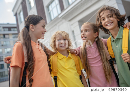 Schoolchildren playing in school yard and looking happy Schoolchildren playing in school yard and looking happy 69670340