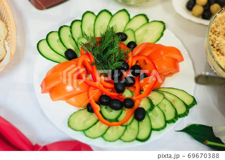 vegetable slicing of tomato, cucumber, pepper with olives and dill on a plate 69670388