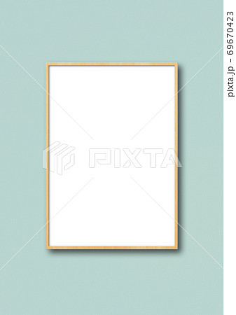 Wooden picture frame hanging on a light blue wall 69670423