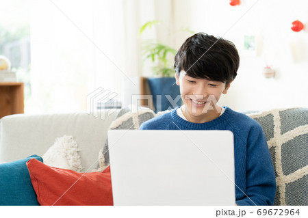 ビデオ通話をする若い男性【リビング】 69672964