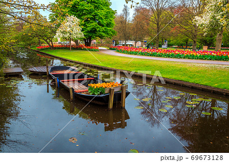 Ornamental boat and colorful fresh tulips in Keukenhof park, Netherlands 69673128