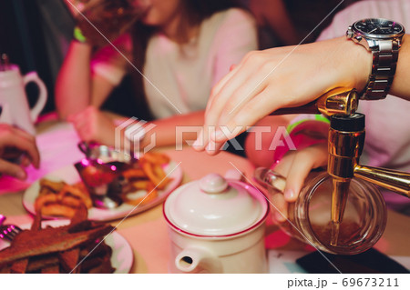 Close up shot of group of people clinking glasses with beer in front of bokeh background. older people hands. Close up shot of group of people clinking glasses with beer in front of bokeh background. older people hands. 69673211