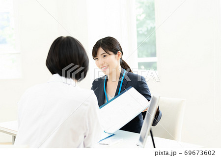 医師に情報提供するMR女性 69673602