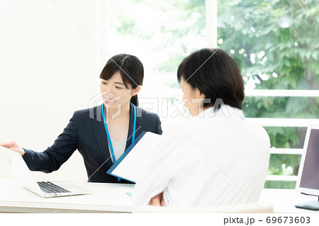 医師に情報提供するMR女性 69673603
