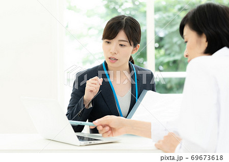 医師に情報提供するMR女性 69673618