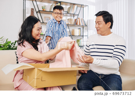 Happy woman opening giftbox Happy woman opening giftbox 69673712