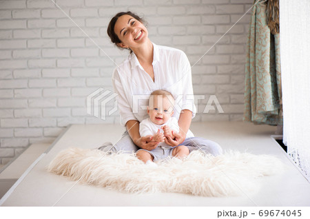 Mom and baby boy in diaper playing in sunny bedroom. Family havi 69674045