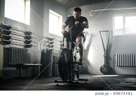 Sportive Man Train Legs On Stationary Bike . Sportive Man Train Legs On Stationary Bike . 69674381