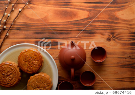 Top view of rustic table with traditional moon cakes, tea set and copy space Top view of rustic table with traditional moon cakes, tea set and copy space 69674416