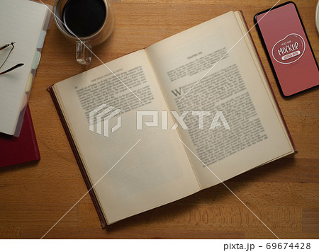 Study table with opened book, mock up smartphone and stationery Study table with opened book, mock up smartphone and stationery 69674428