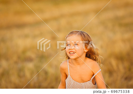 close up happy kid girl grey dress run wheat field 69675338