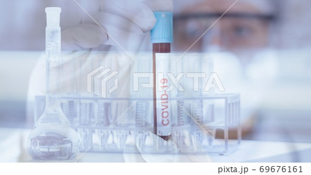 Digital illustration of a doctor and googles and gloves,holding a tube with a COVID19 sign 69676161