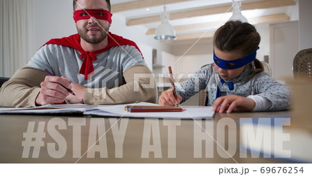 Caucasian man and girl wearing capes with words Stay Home during coronavirus covid19 pandemic Caucasian man and girl wearing capes with words Stay Home during coronavirus covid19 pandemic 69676254