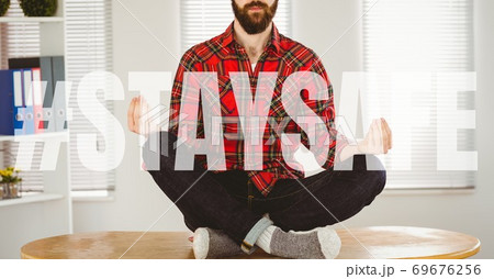 Caucasian man meditating with words Stay Safe during coronavirus covid19 pandemic Caucasian man meditating with words Stay Safe during coronavirus covid19 pandemic 69676256