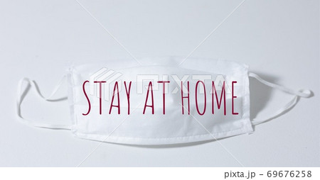 Digital illustration of a face mask with a red sign Stay at home on a white background Digital illustration of a face mask with a red sign Stay at home on a white background 69676258