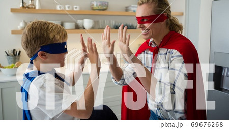 Caucasian woman and boy wearing capes with words Stay Safe during coronavirus covid19 pandemic Caucasian woman and boy wearing capes with words Stay Safe during coronavirus covid19 pandemic 69676268