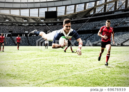 Digital composite image of rugby player jumping with the ball in sports stadium Digital composite image of rugby player jumping with the ball in sports stadium 69676939
