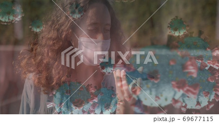 Covid-19 cells against woman wearing face mask talking on smartphone Covid-19 cells against woman wearing face mask talking on smartphone 69677115