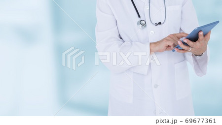 Mid section of male doctor using digital tablet in hospital during pandemic coronavirus Mid section of male doctor using digital tablet in hospital during pandemic coronavirus 69677361