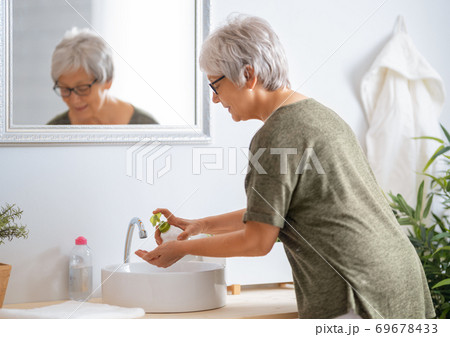 Person is washing hands with soap. Person is washing hands with soap. 69678433