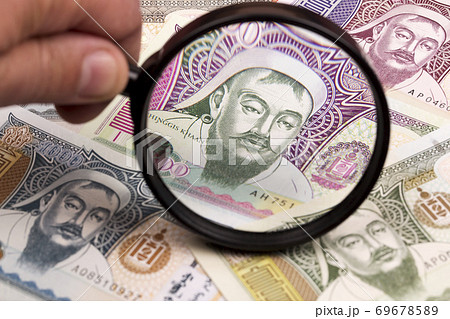 Mongolian money in a magnifying glass a business background Mongolian money in a magnifying glass a business background 69678589