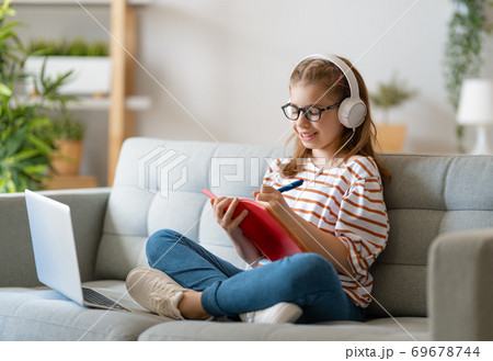 Girl doing homework or online education. Girl doing homework or online education. 69678744