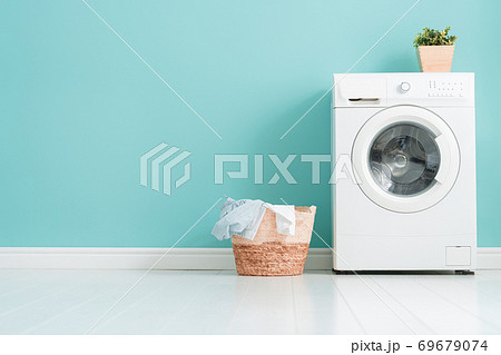 washing machine on teal wall background 69679074