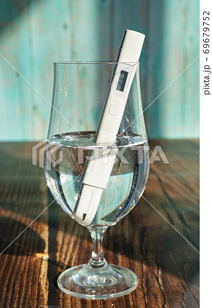 TDS meter in glass to determine quality of water. TDS meter in glass to determine quality of water. 69679752