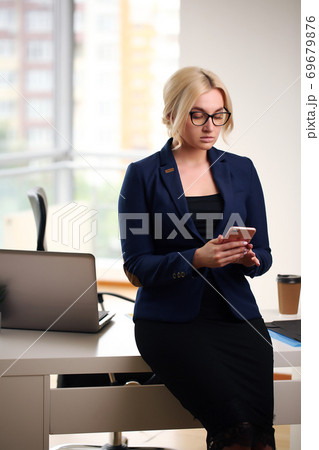 Young blonde businesswoman sitting at desk in the office 69679876