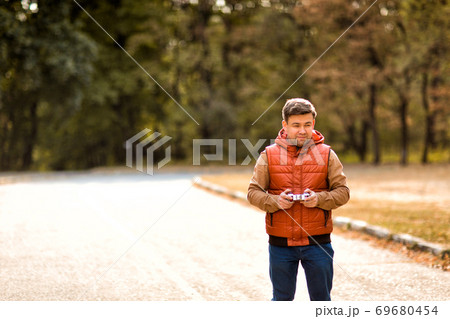 man playing with toy car on remote control man playing with toy car on remote control 69680454