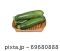 uncooked whole fresh zucchini in bamboo basket on white background 69680888