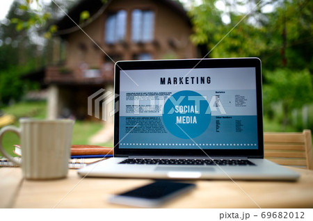Laptop on desk outdoors in garden, home office concept. 69682012