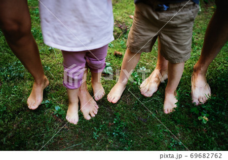 Bare feet of family with small children standing barefoot outdoors in nature, grounding concept. 69682762