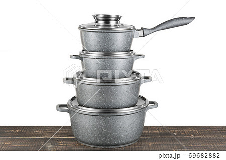 a set of gray enamel crockery stands in a pile on a wooden table, modern pots 69682882