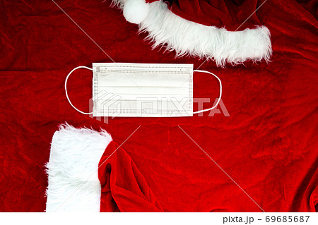 Santa Claus red hat with medical face mask on Santa Claus suit Fabric, Covid-19 and Christmas concept, background texture Santa Claus red hat with medical face mask on Santa Claus suit Fabric, Covid-19 and Christmas concept, background texture 69685687