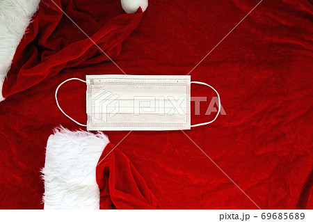 Santa Claus red hat with medical face mask on Santa Claus suit Fabric, Covid-19 and Christmas concept, background texture 69685689