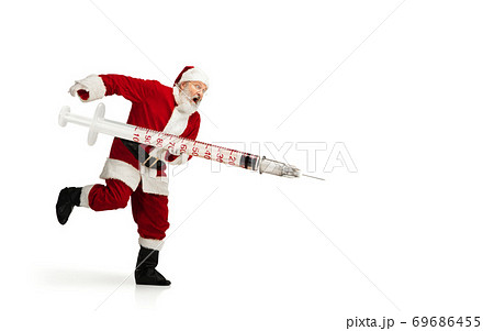 Santa Claus holding huge vaccine against COVID like Christmas gift isolated on white background 69686455