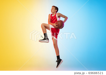 Full length portrait of a young basketball player with ball on gradient background 69686521