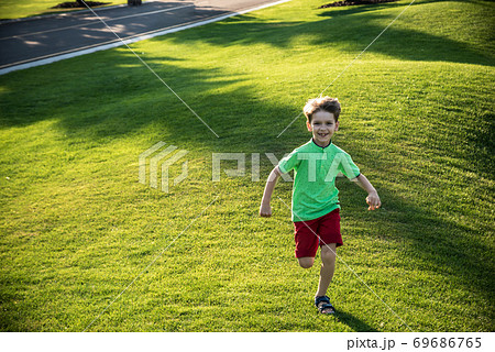 Little boy running on the grass on huge golf field 69686765