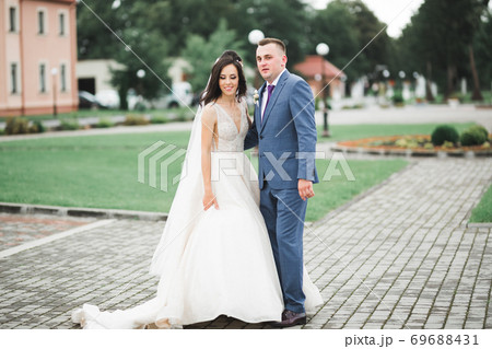Wedding couple on the nature is hugging each other. Beautiful model girl in white dress. Man in suit Wedding couple on the nature is hugging each other. Beautiful model girl in white dress. Man in suit 69688431