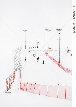 Ski slope with skiers in winter landscape Ski slope with skiers in winter landscape 69689919