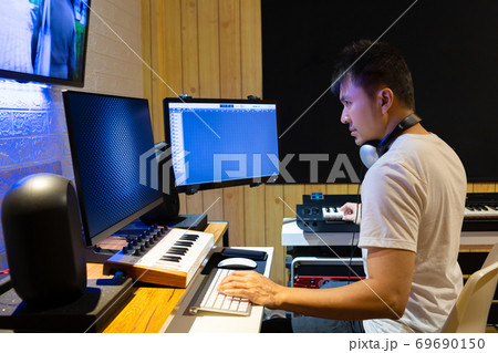 asian professional producer composing, editing music score on movie footage asian professional producer composing, editing music score on movie footage 69690150