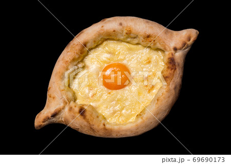 Adjarian khachapuri isolated on black background. National Georgian dish. Adjarian khachapuri isolated on black background. National Georgian dish. 69690173