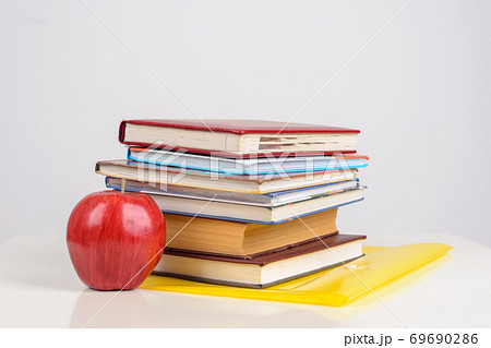 colorful Books and ripe Apple close on table on white background 69690286