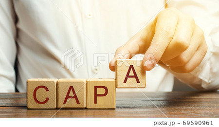 Businessman puts wooden blocks with the word CAPA. Corrective and Preventive action plans. Business management concept. Strategy and efficiency. Improving organizational processes. Performance 69690961