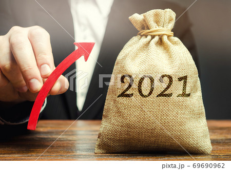 Businessman holds an up arrow near the 2021 money bag. Strategy and budget planning. Vision. Business forecasting. Growth and development of business and economic. Goals and plans. Investment. 69690962
