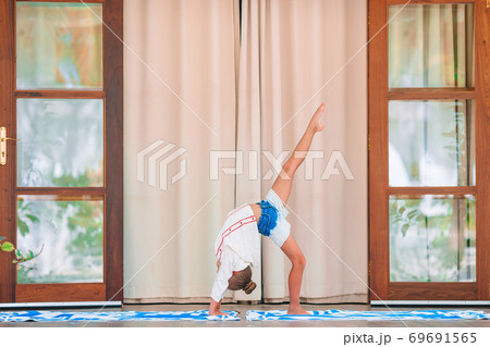 Happy sporty kid meditating on the terrace Happy sporty kid meditating on the terrace 69691565